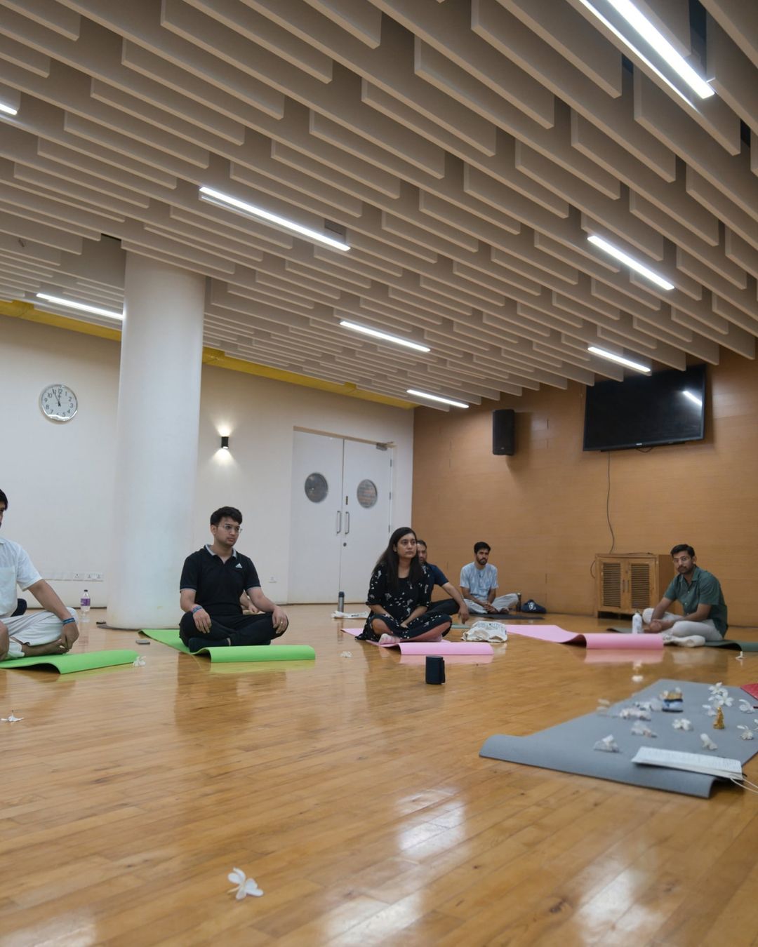 Vishal seated on the floor, talking with a group before a breathwork session at a university studio