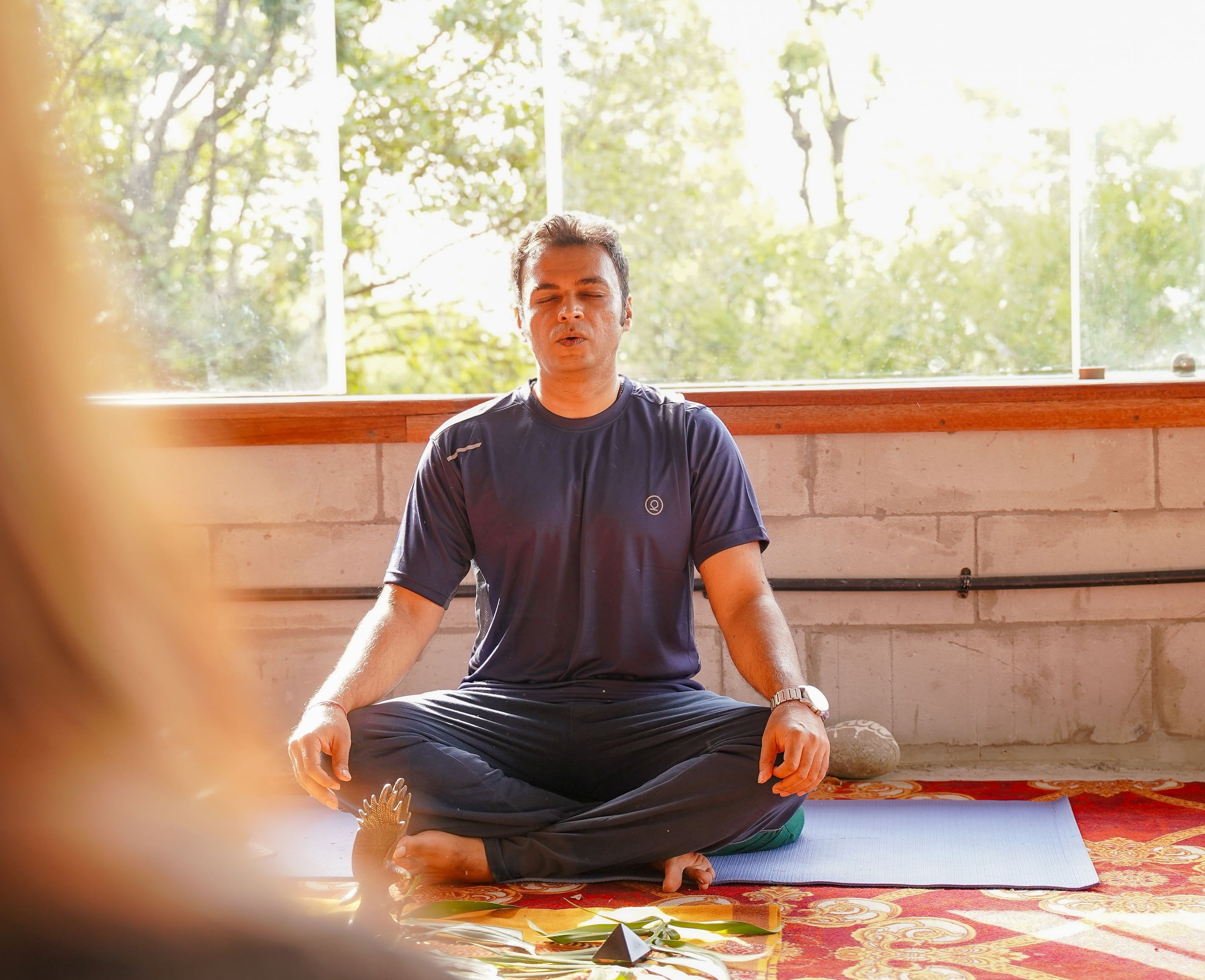 Vishal seated cross-legged on a mat, eyes closed, breathing